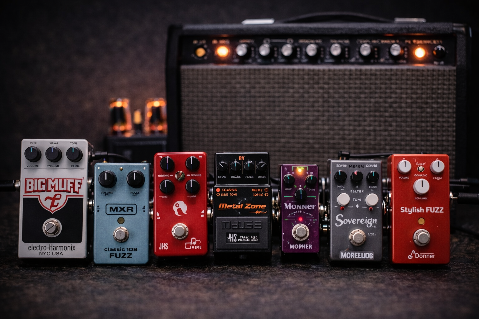 best fuzz pedal hero image: seven fuzz pedals lined up in front of a tube amp