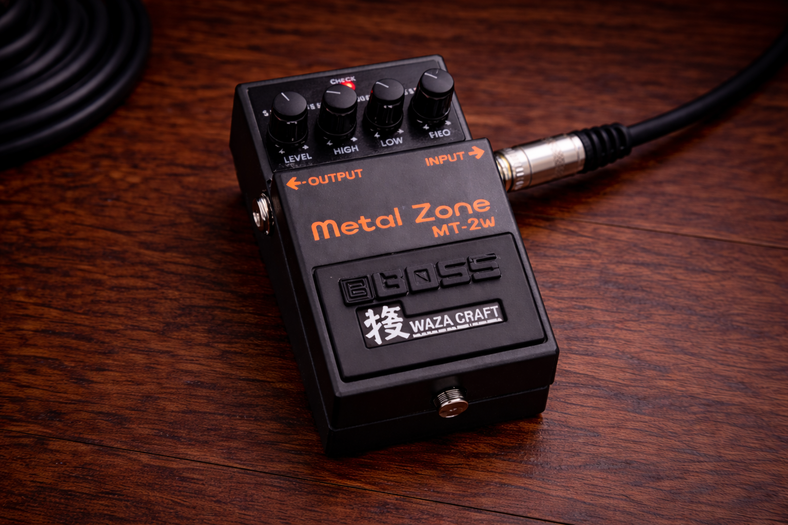 boss mt 2 metal zone: slightly wider close-up of a Boss MT-2W Metal Zone pedal on a wooden desk