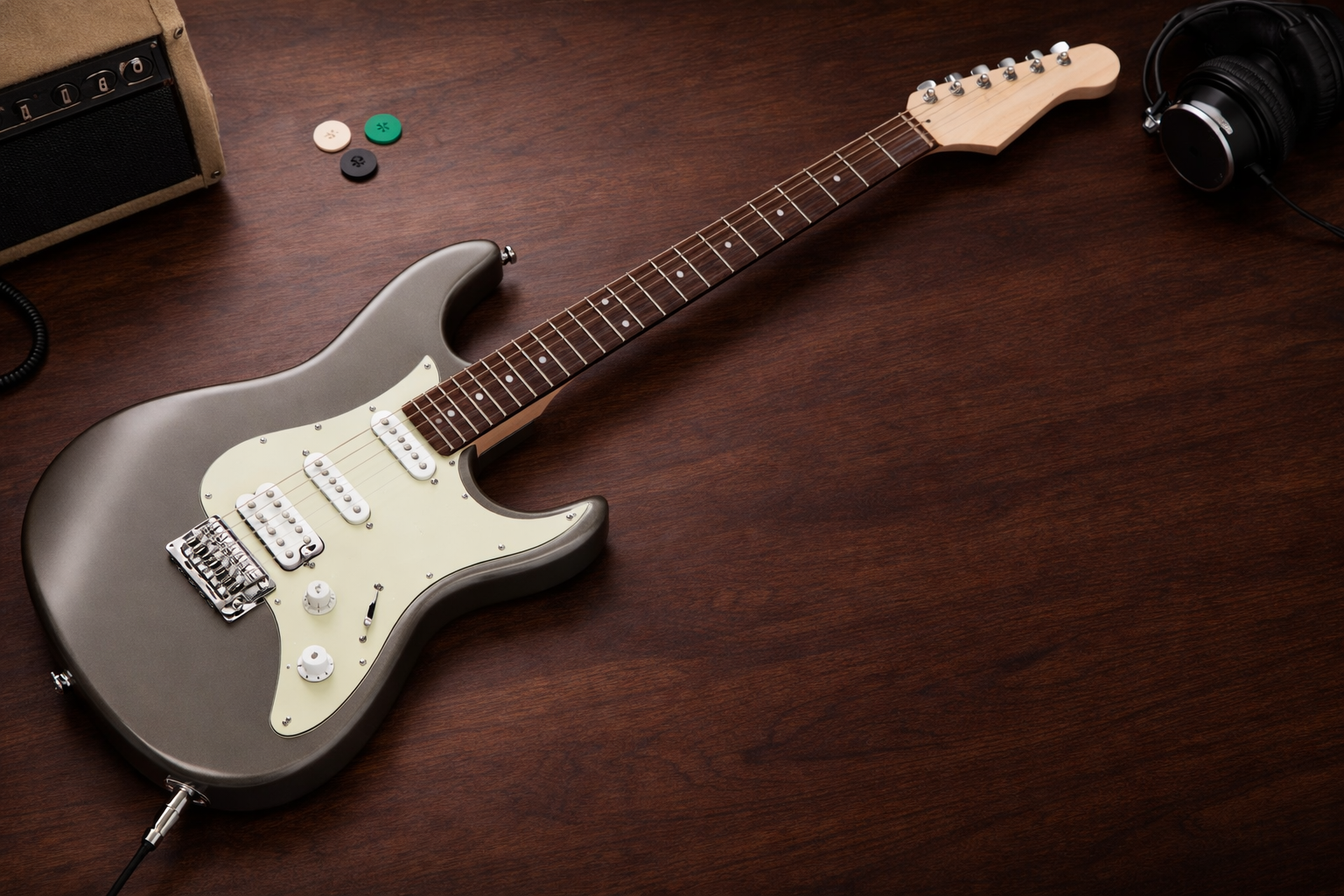 Ibanez AZES40 review hero image: metallic gray HSS electric guitar on a dark wooden desk