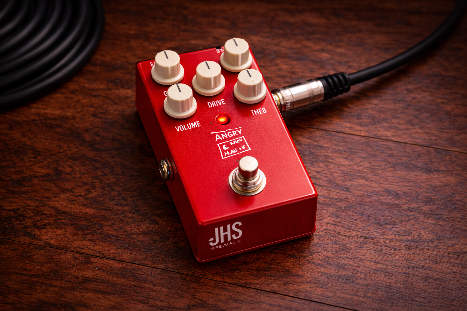 jhs angry charlie: slightly wider close-up of a JHS Angry Charlie V3 distortion pedal on a wooden desk