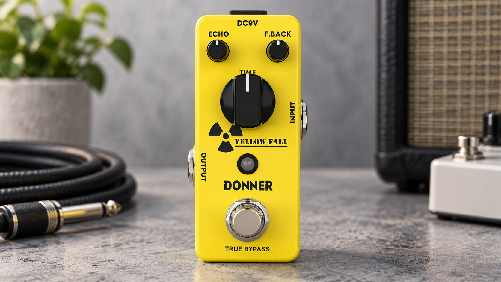 Donner Yellow Fall review image showing the yellow mini delay pedal in a clean studio setup.